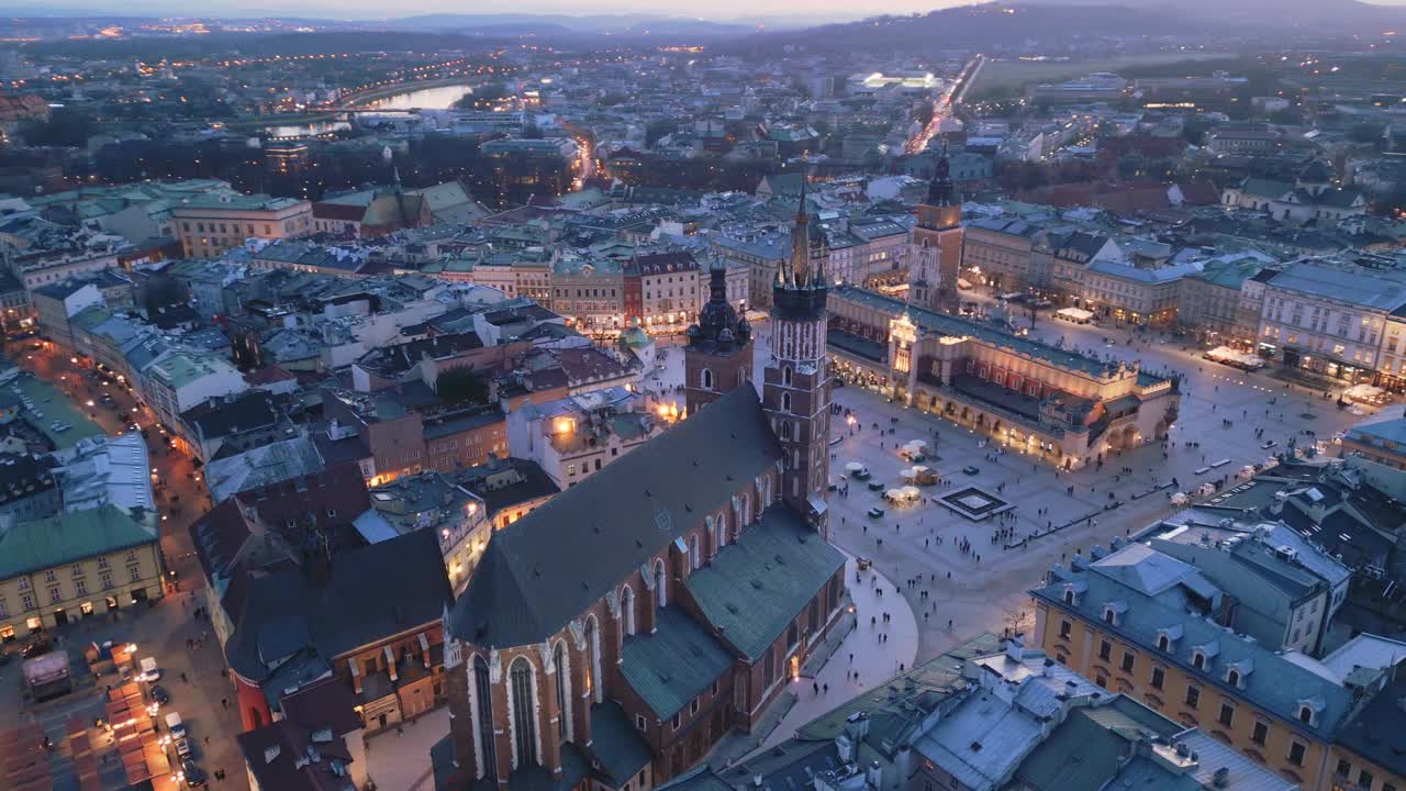 克拉科夫主要市场广场夜间无人机鸟瞰图。照明纪念碑:Mariacki(圣玛丽)教堂，Sukiennice(布厅)和市政厅塔视频素材