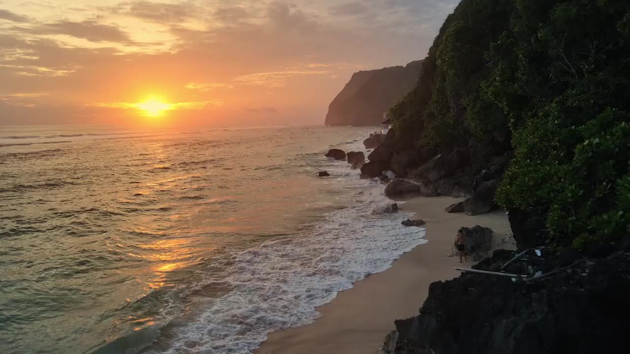 美丽的海洋海岸线在Melasti海滩与温暖的日落或日出在巴厘岛。鸟瞰图视频素材