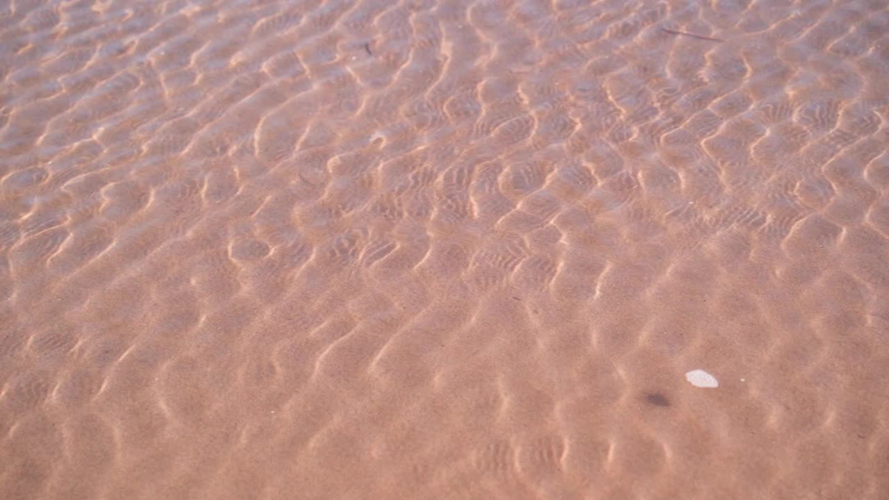 初升的太阳光线反射在浅水区的流水上。视频素材