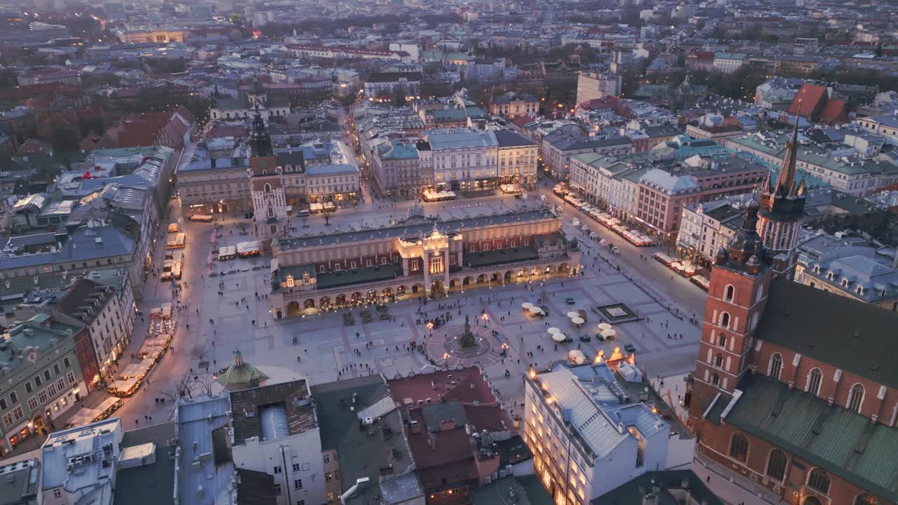 克拉科夫主要市场广场夜间无人机鸟瞰图。照明纪念碑:Mariacki(圣玛丽)教堂，Sukiennice(布厅)和市政厅塔视频素材