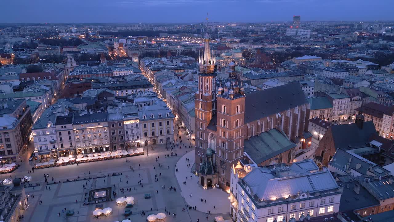 克拉科夫主要市场广场夜间无人机鸟瞰图。照明纪念碑:Mariacki(圣玛丽)教堂，Sukiennice(布厅)和市政厅塔视频素材