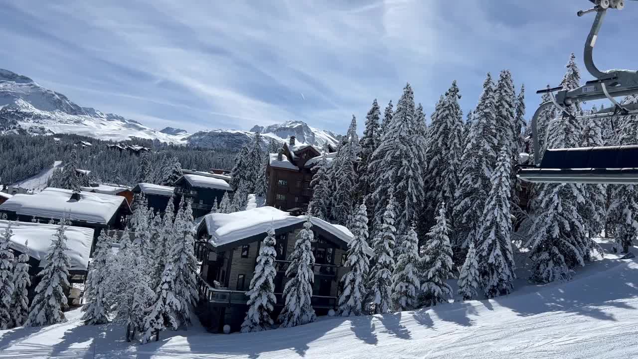 在法国阿尔卑斯山脉的Courchevel滑雪胜地，冬天的小木屋被雪覆盖视频素材