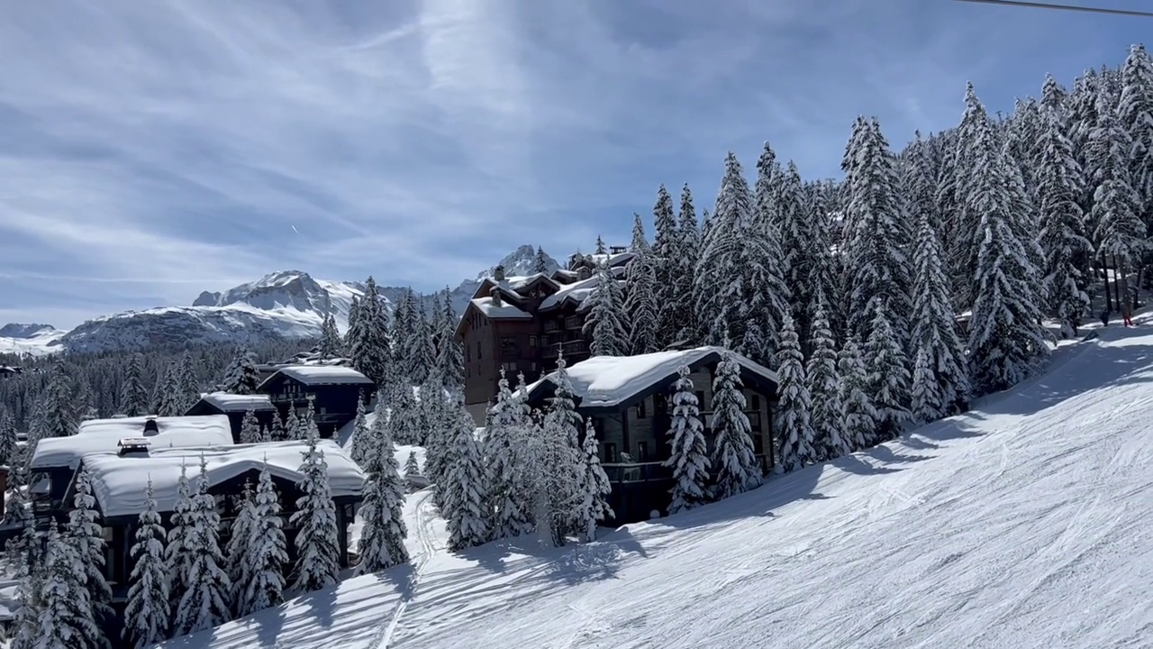 在法国阿尔卑斯山脉的Courchevel滑雪胜地，冬天的小木屋被雪覆盖视频素材