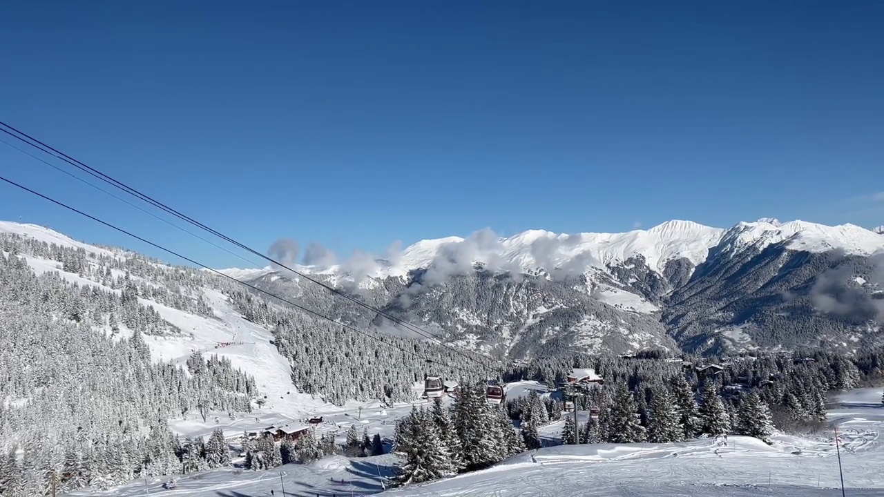 在法国阿尔卑斯山脉的Courchevel滑雪胜地，冬天的小木屋被雪覆盖视频素材