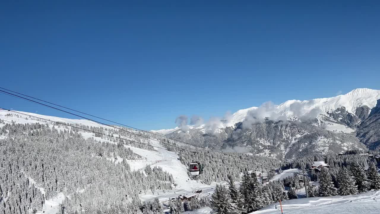 在法国阿尔卑斯山脉的Courchevel滑雪胜地，冬天的小木屋被雪覆盖视频素材