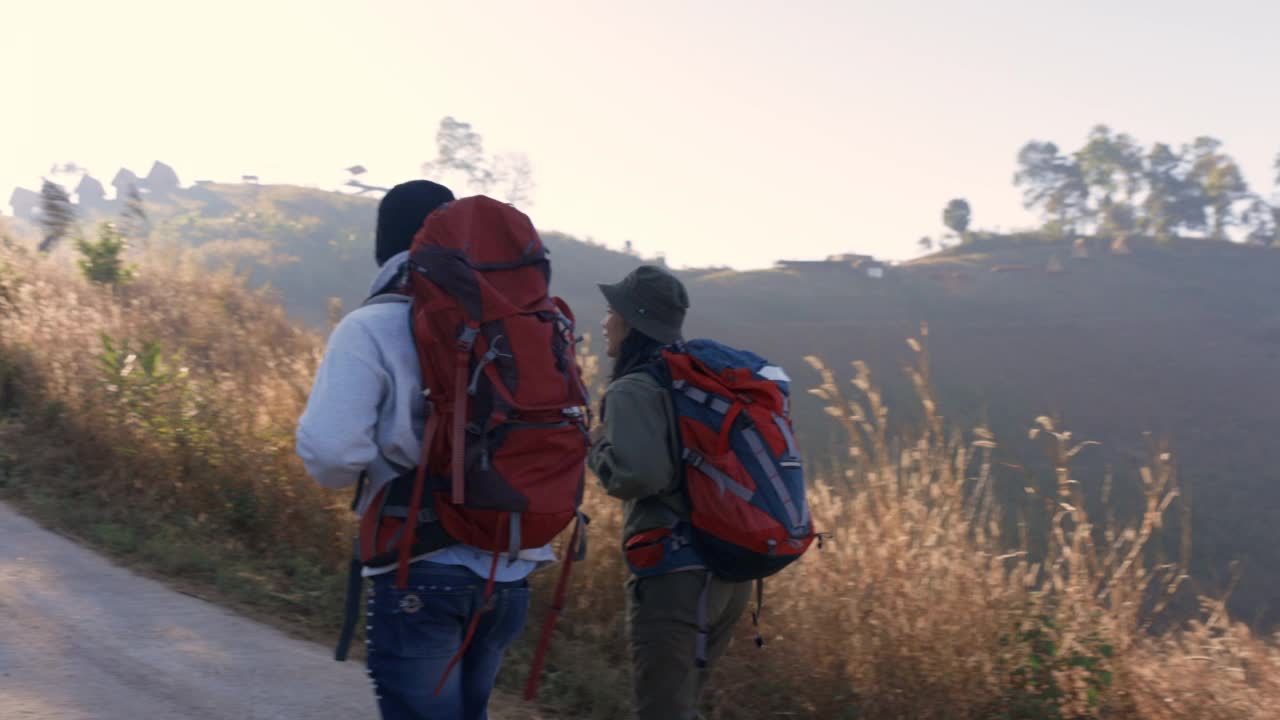 男性和女性亚洲旅行者徒步登山的后视图视频素材