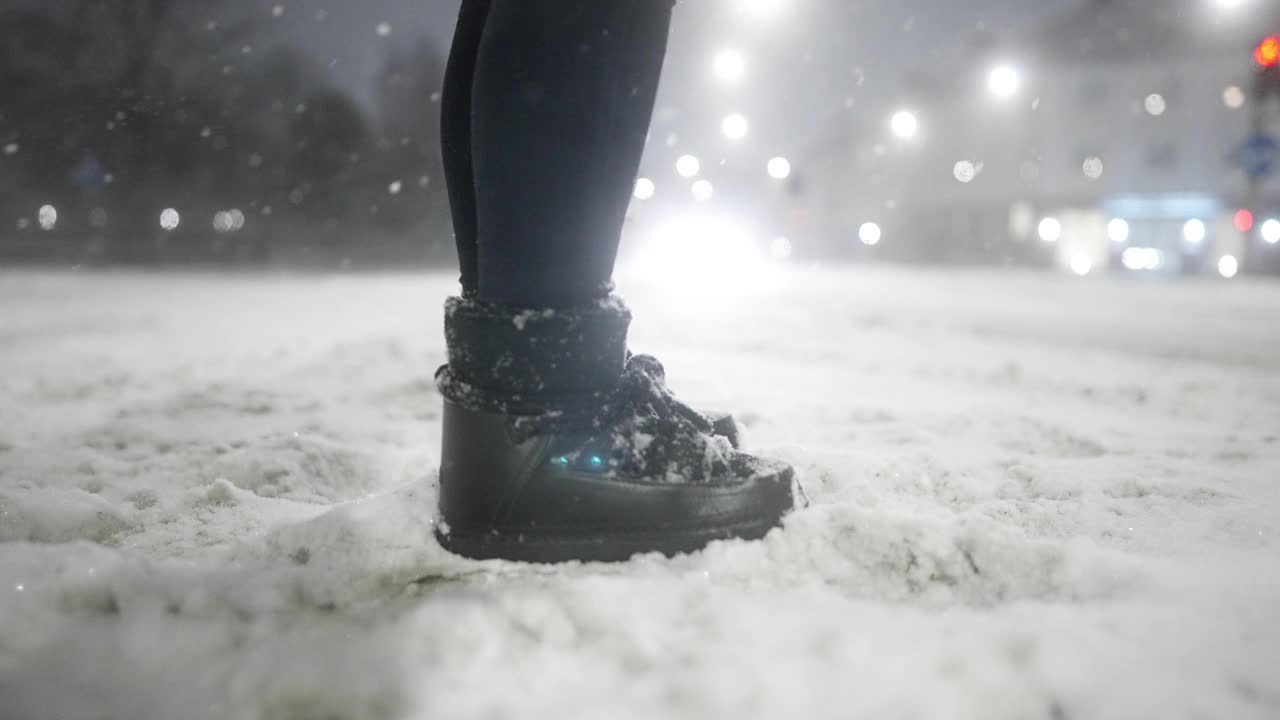 一个女人站在城市里，看着雪视频素材