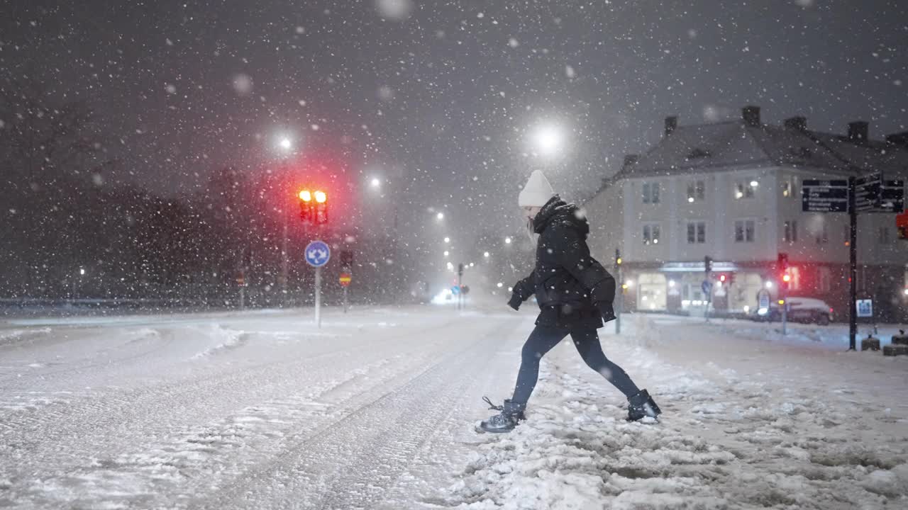 一个女人在暴风雪中过马路视频素材