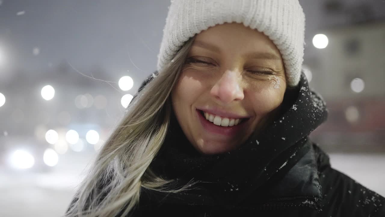 一个快乐的女人的肖像在一个雪夜，在城市视频素材