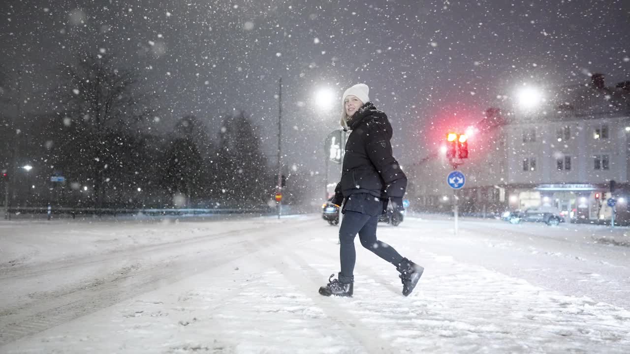 一个女人在暴风雪中过马路视频素材