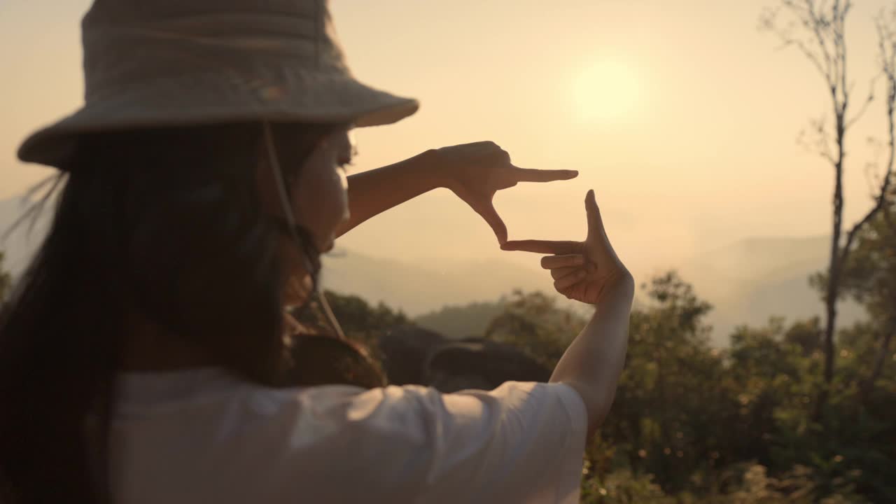 女性旅行在晚上的悬崖上制作相机符号视频素材