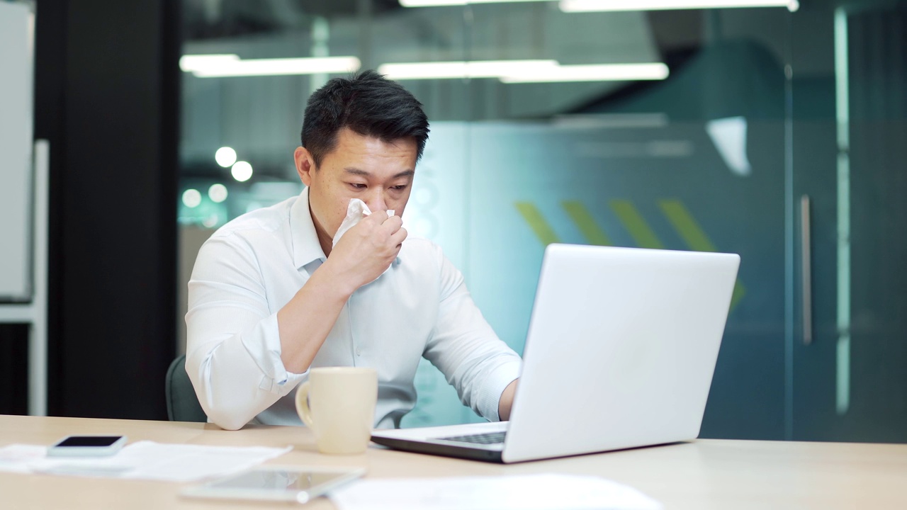 英俊的亚洲男性工人患有过敏，打喷嚏流鼻涕视频素材