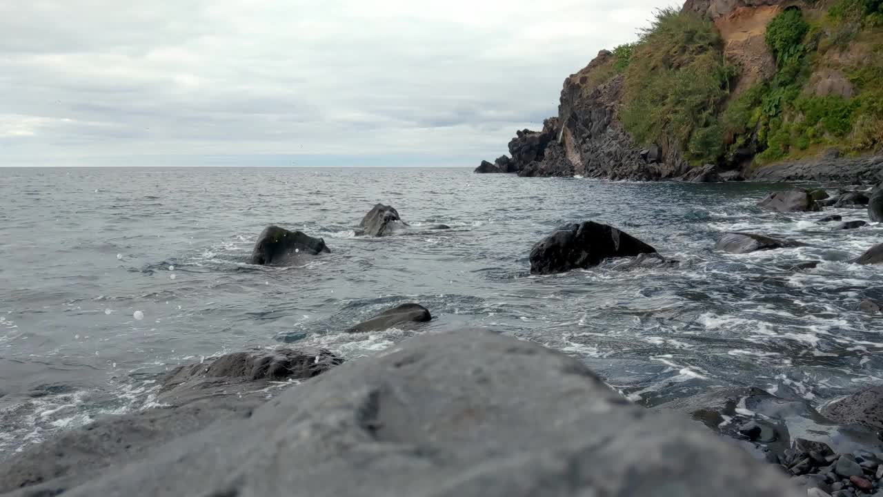 岛上由火山岩组成的岩石海岸。波浪冲刷着岩石视频素材