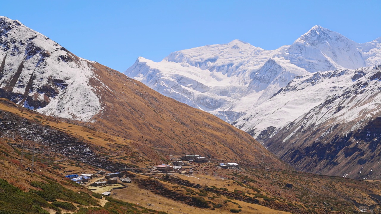 在秋天，喜马拉雅山脉的雪峰，小村庄和自然景观的戏剧性全景，安纳普尔纳电路徒步旅行，尼泊尔视频素材