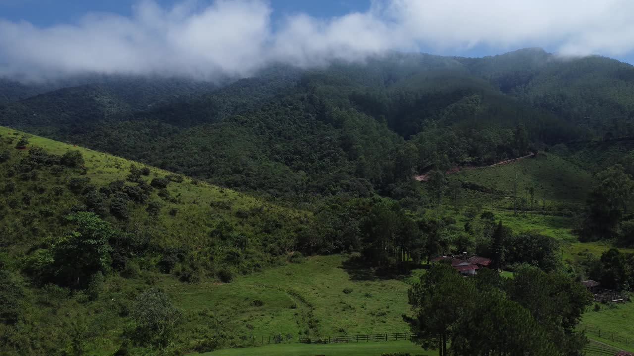 Aerial view of beautiful forest full of nature and pasture fields in Tremembé in Vale da Paraíba in São Paulo. Mountains and hills in sunny day. Lots of green and tropical vegetation. Drone视频素材