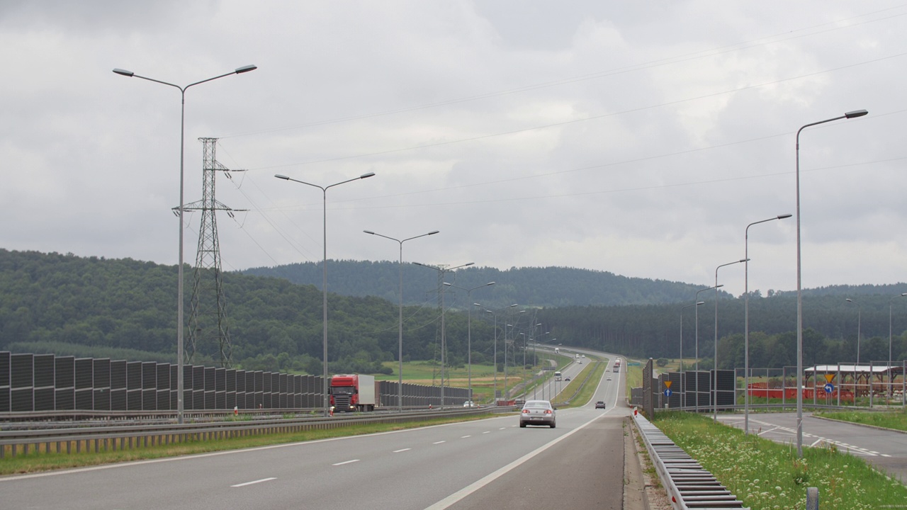 现代高速公路行驶轿车和重型卡车，丘陵景观阴天视频素材