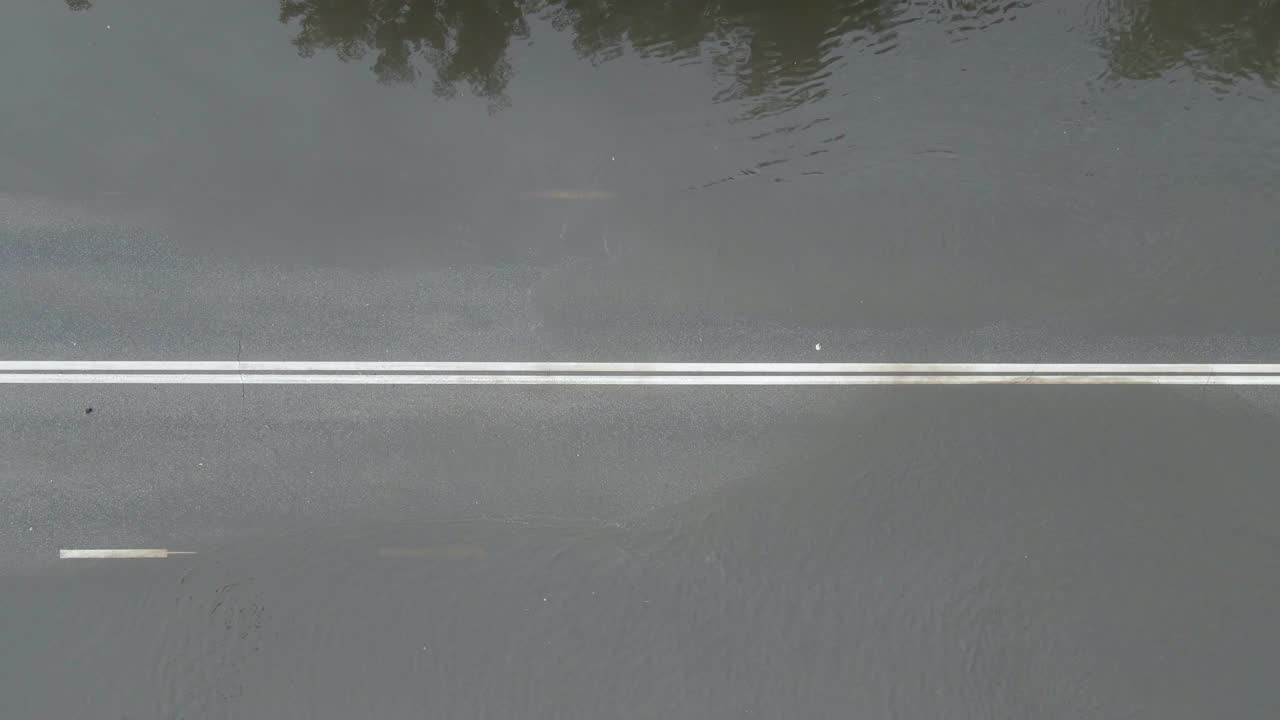 城市交通鸟瞰图，大雨后汽车行驶在被洪水淹没的街道上。道路排水系统问题视频素材