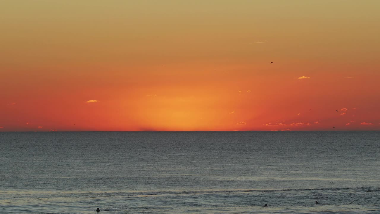 冲浪者在葡萄牙大西洋海岸夕阳背景下的海滩上。视频素材