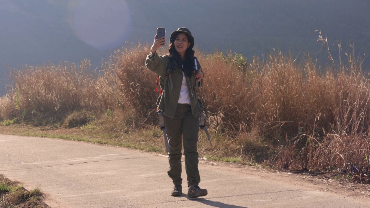 女性背包客在山上散步并拍照视频素材