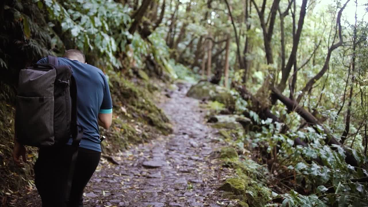 运动员们在雨后沿着泥泞的小路徒步穿过山脉视频素材