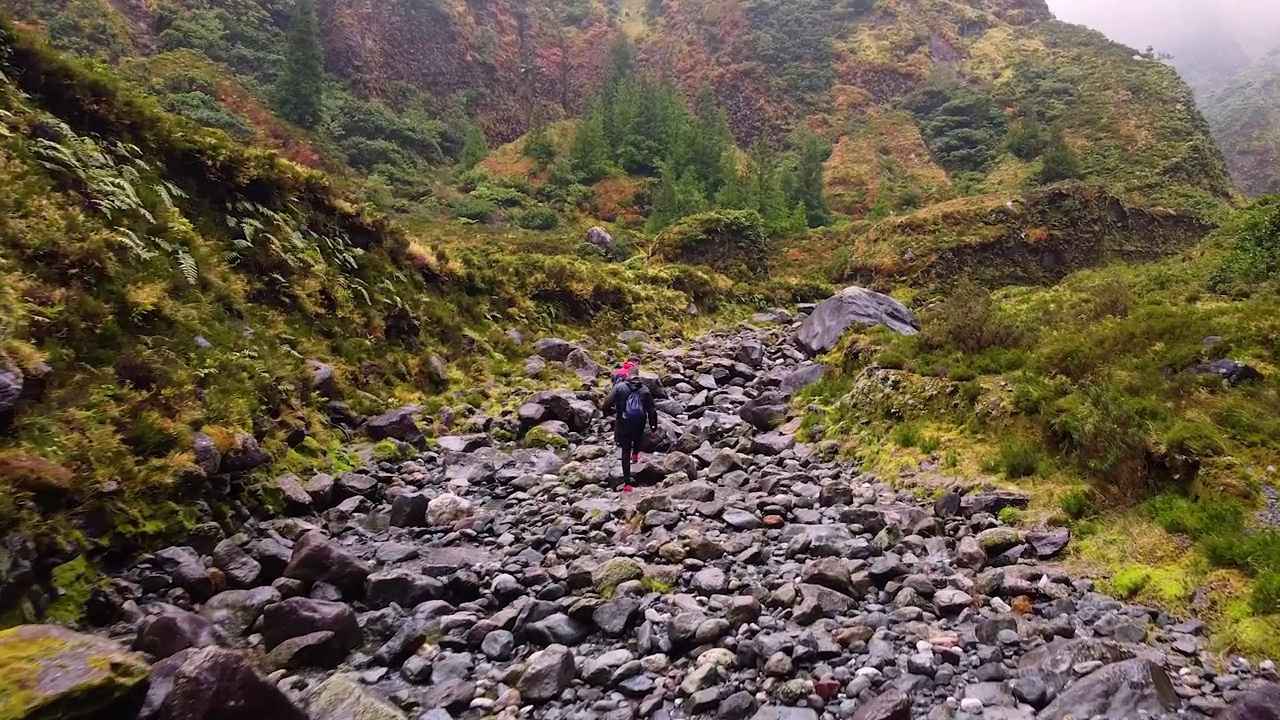 运动员们在雨后沿着泥泞的小路徒步穿过山脉视频素材