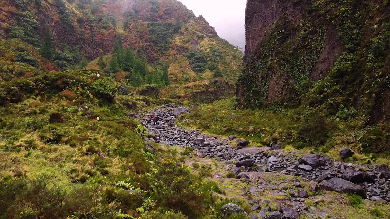 运动员们在雨后沿着泥泞的小路徒步穿过山脉视频素材