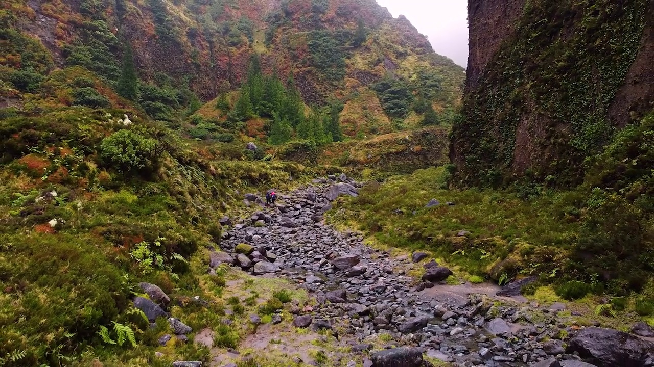 运动员们在雨后沿着泥泞的小路徒步穿过山脉视频素材