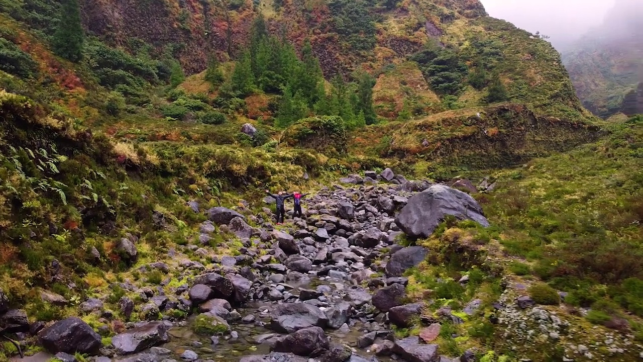 运动员们在雨后沿着泥泞的小路徒步穿过山脉视频素材