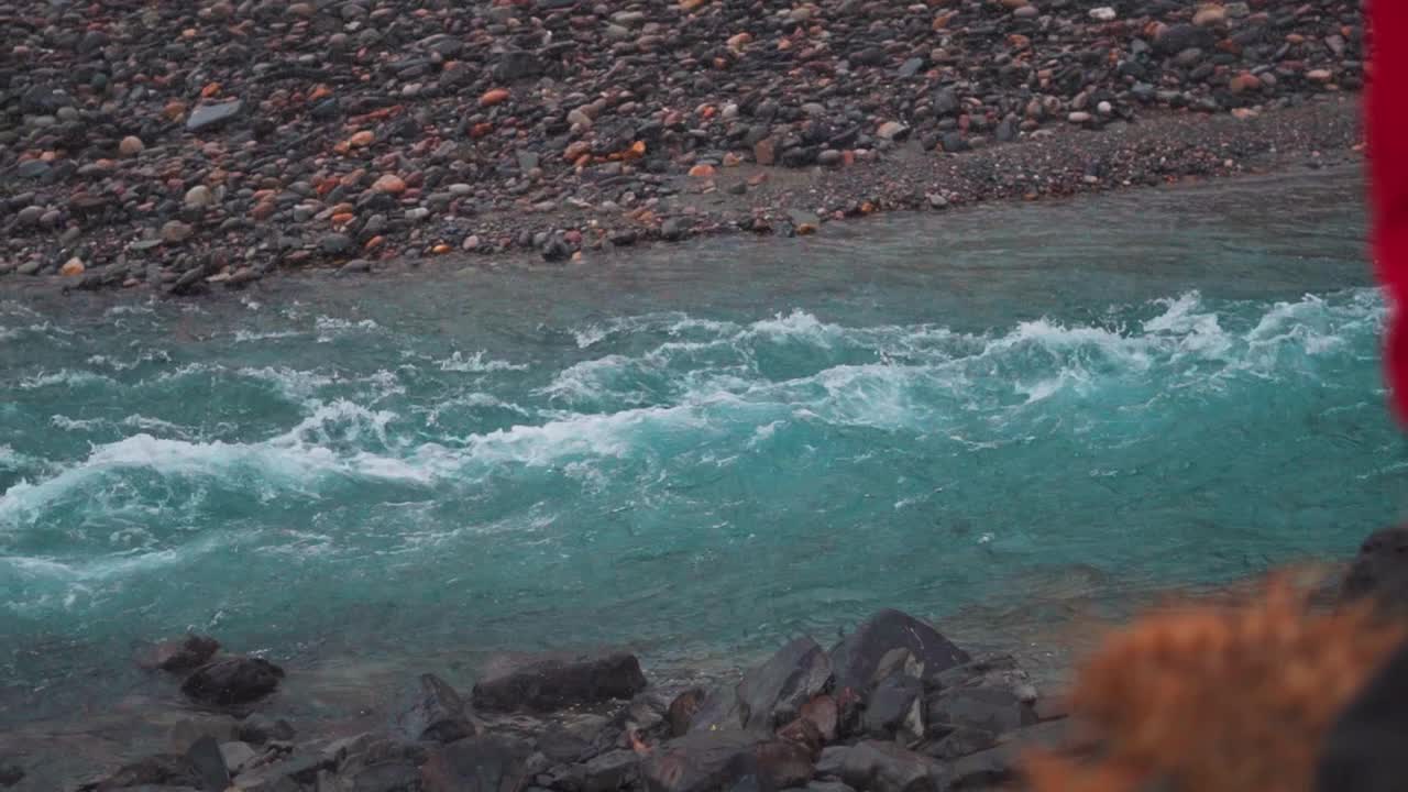 钱德拉河在印度喜马偕尔邦西苏的降雪中在山脉之间流动的慢动作镜头。喜马拉雅山脉降雪期间蓝色绿松石色河流的慢动作。视频素材