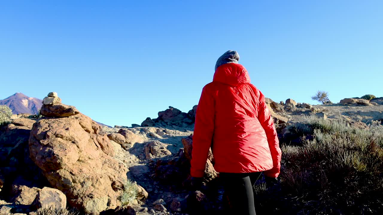 一个女人走到悬崖顶上去看泰德火山视频素材