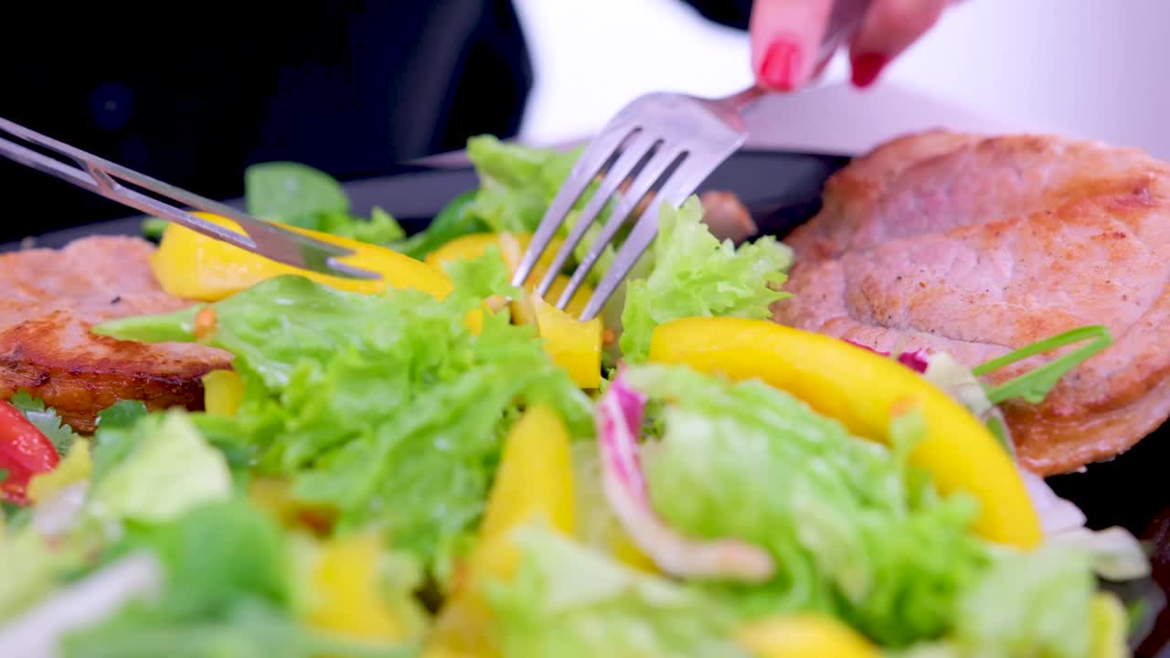 切烤肉慢动作，在盘子里切肉，切烤肉特写，用马苏里拉奶酪和番茄做沙拉视频素材