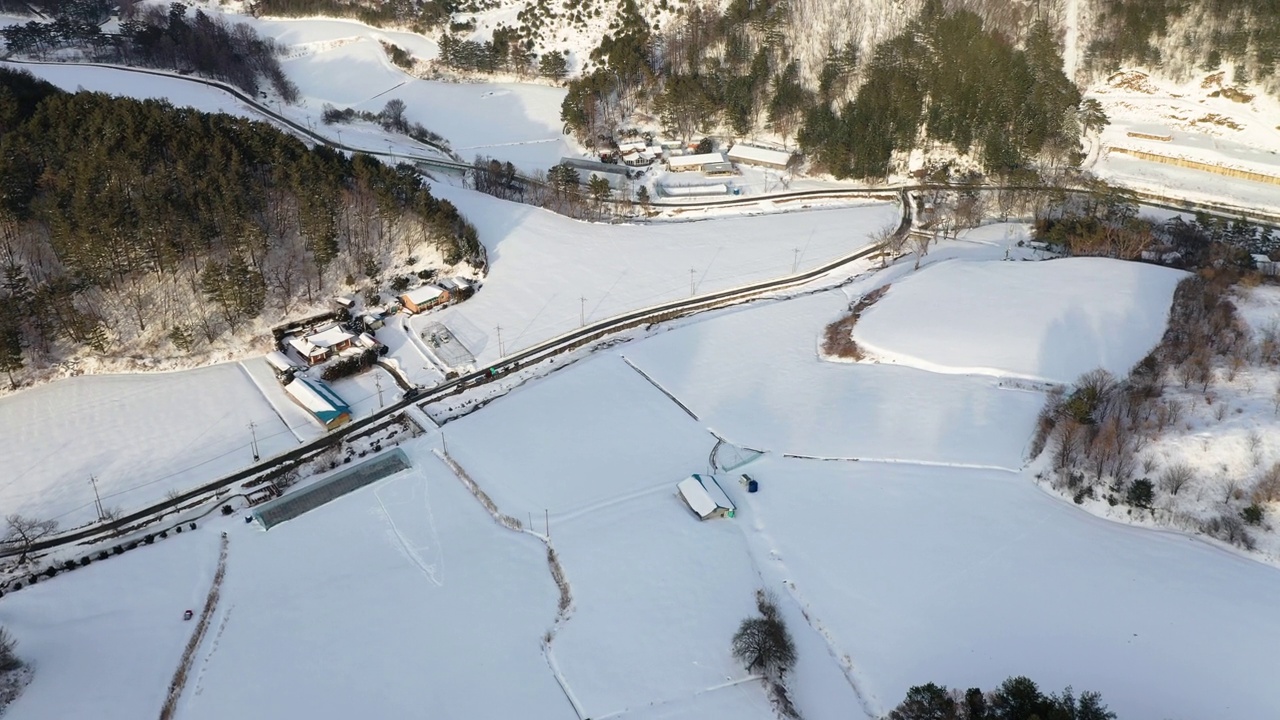 图为，韩国江原道平昌郡大关岭附近的山、路、村的雪景视频素材