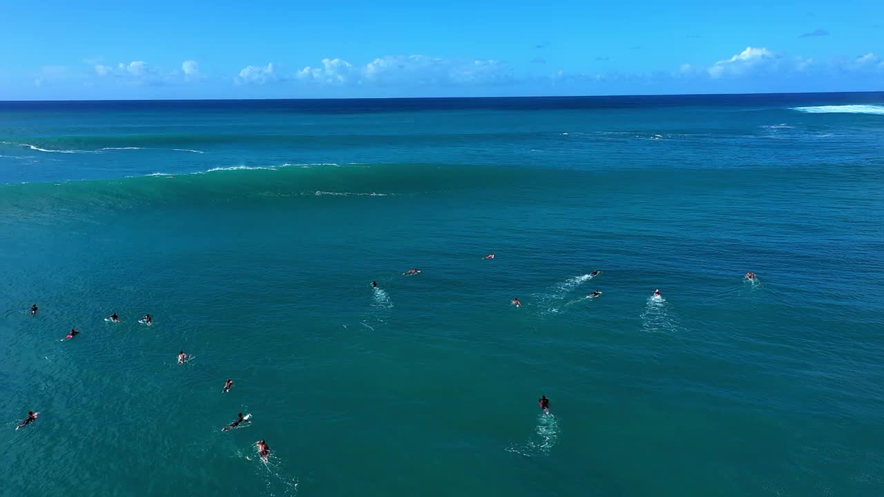 在阳光明媚的日子里，人们在海洋中的海浪上冲浪的镜头——夏威夷瓦胡岛视频素材