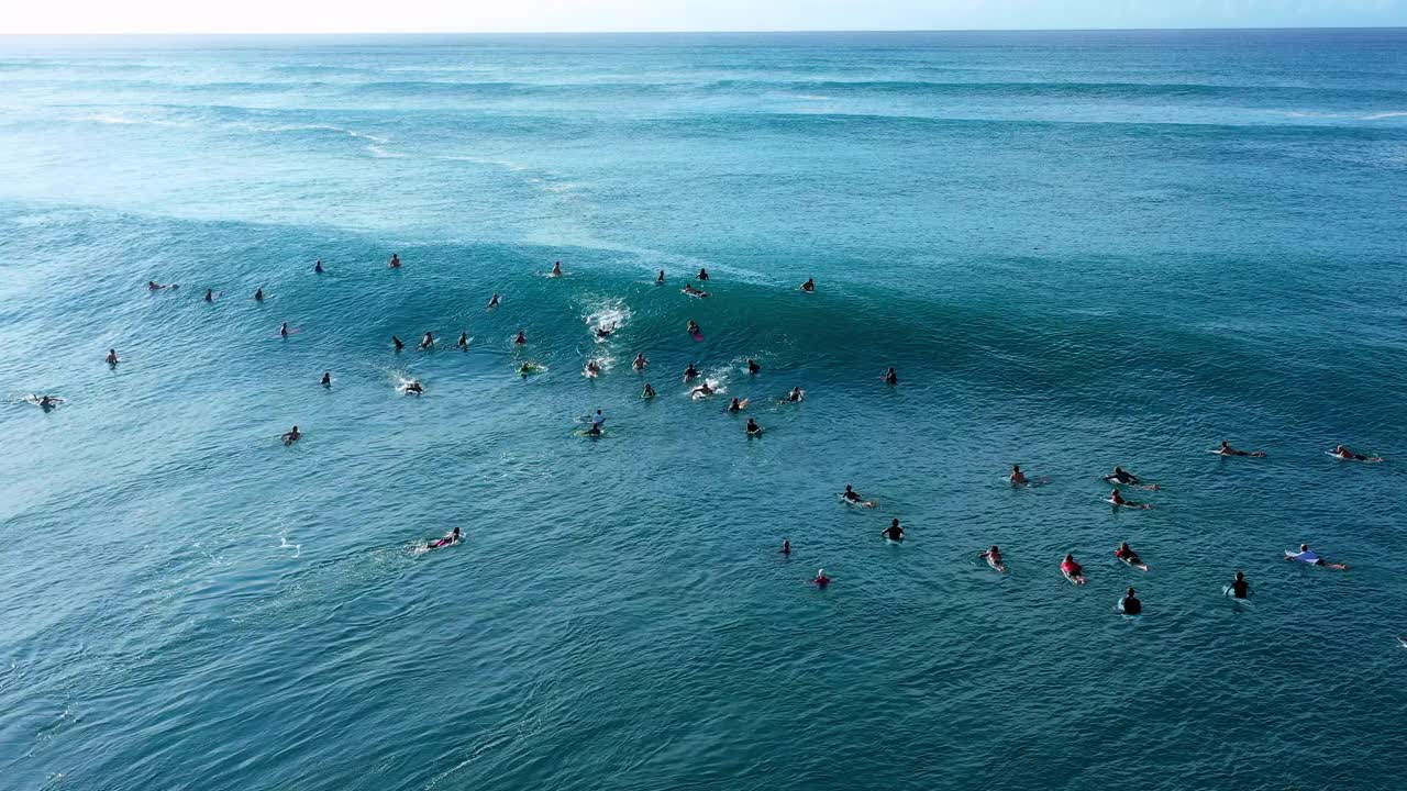 空中向后拍摄的男人和女人与冲浪板在波浪海对天空-瓦胡岛，夏威夷视频素材