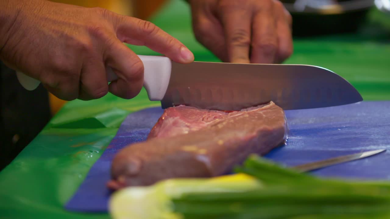 慢动作镜头，男人的手切生肉在餐桌上的商业厨房-洛杉矶，加利福尼亚视频素材