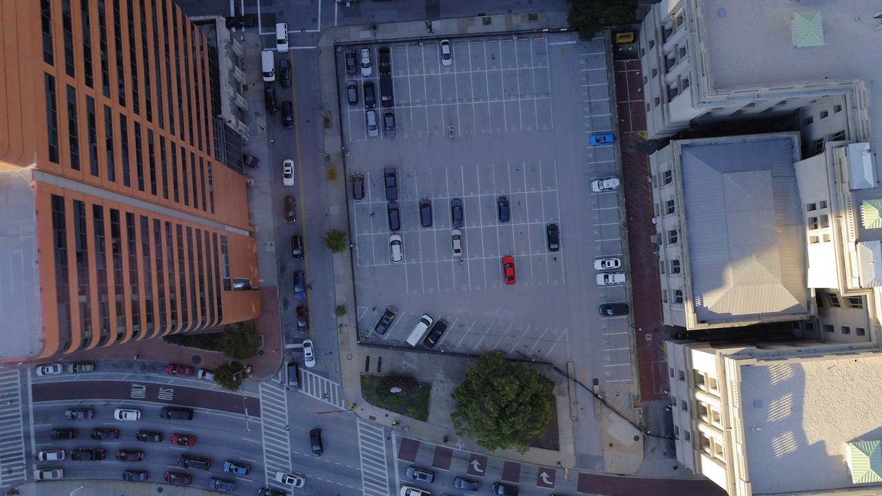 空中慢动作拍摄的车辆在停车场和街道在城市建筑-巴尔的摩，马里兰州视频素材