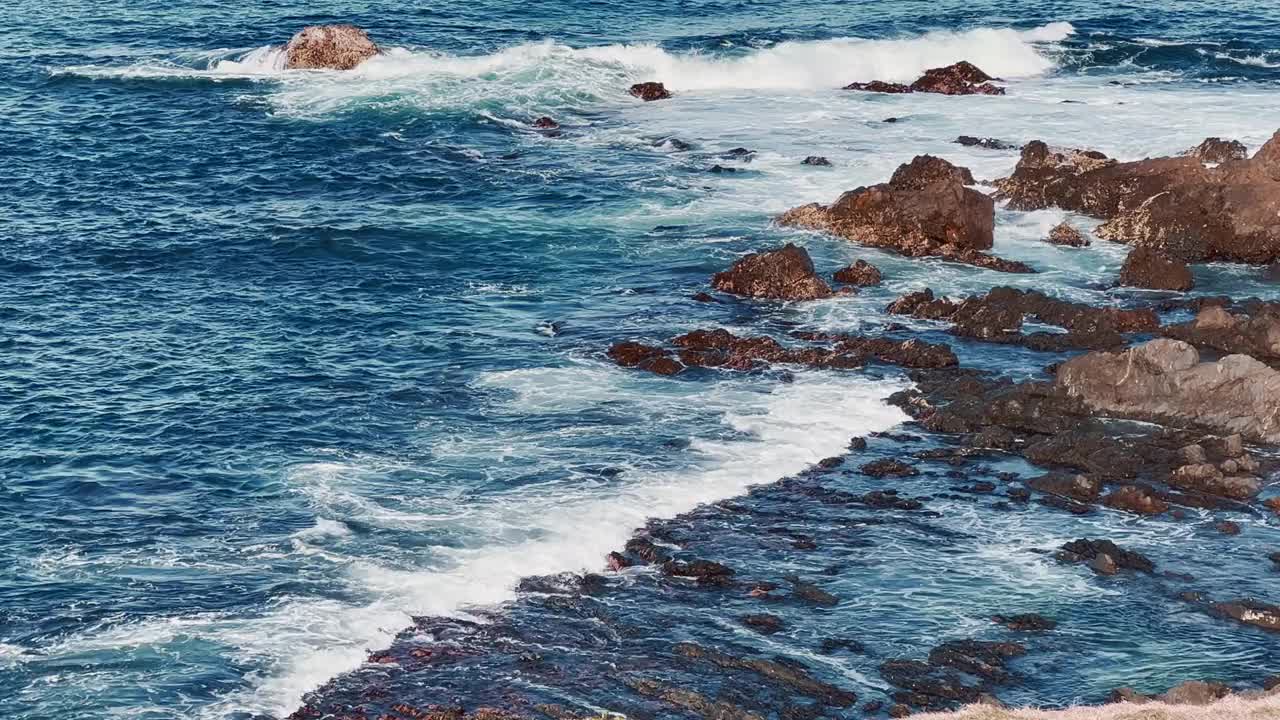 海浪冲击着岩石岬角。视频素材