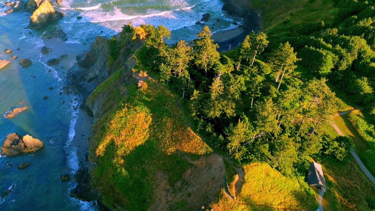 日出盘旋在新月海滩上空，缓缓向上倾斜，向前飞翔，展现出俄勒冈海岸令人惊叹的埃科拉州立公园的景色视频下载