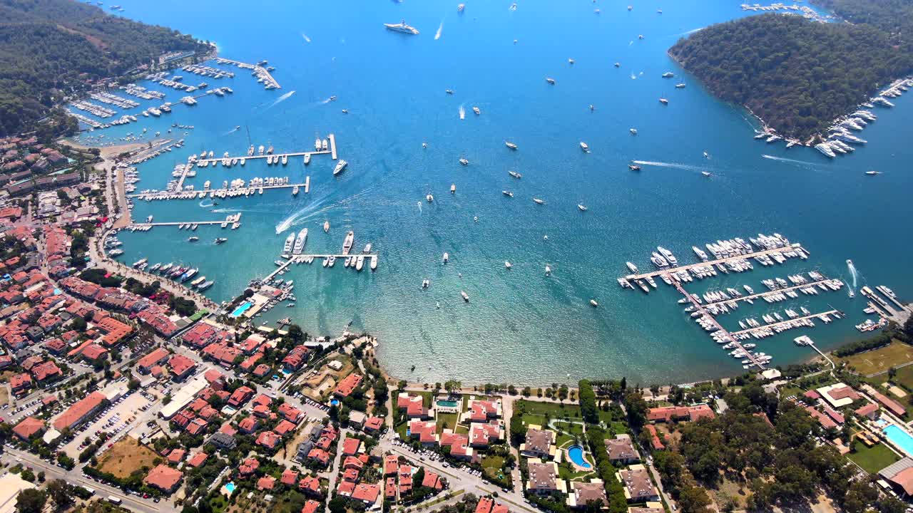 Aerial drone view of the bustling Göcek Marina, located in the beautiful coastal town of Muğla, Turkey, captured by a drone showcasing the vibrant harbor and surrounding landscape.视频素材