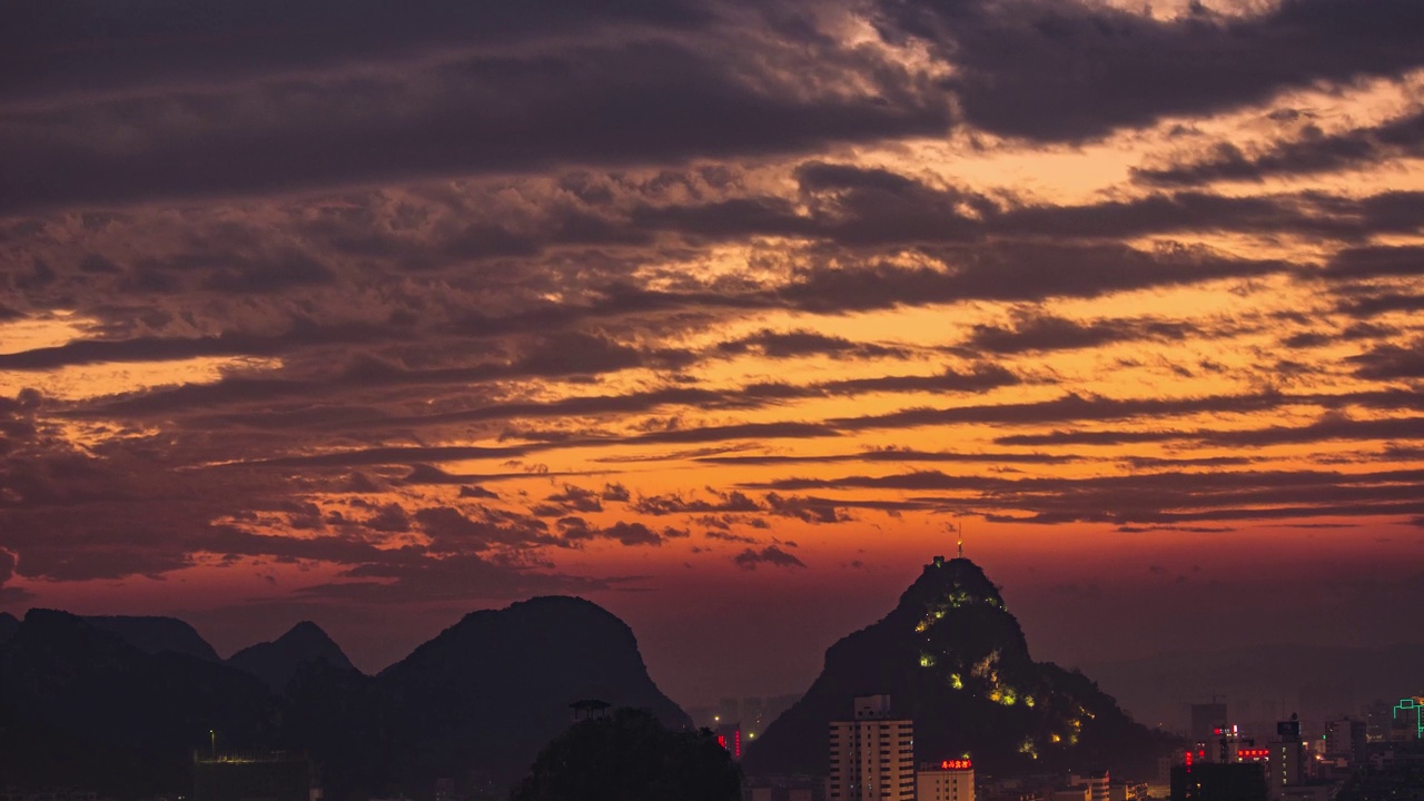 在中国广西柳州，夕阳中的建筑和山丘的4K延时摄影视频素材