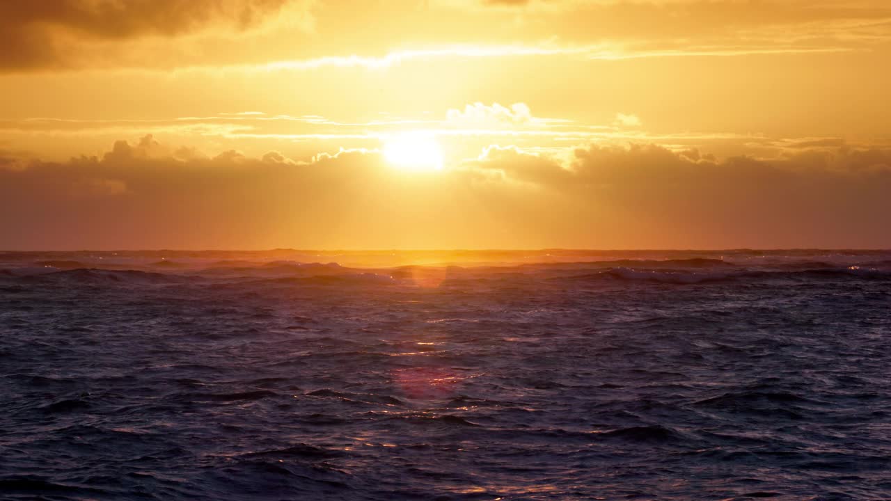 海洋海滩早晨与风景优美的天空云和金色的太阳射线以上的涟漪波，海上日出4k视频视频素材