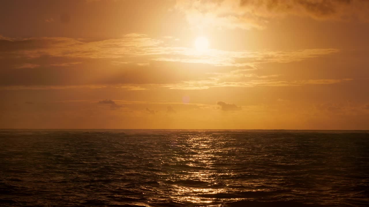 热带海滩的海岸和金色的海水在涟漪的水面上日出视频素材