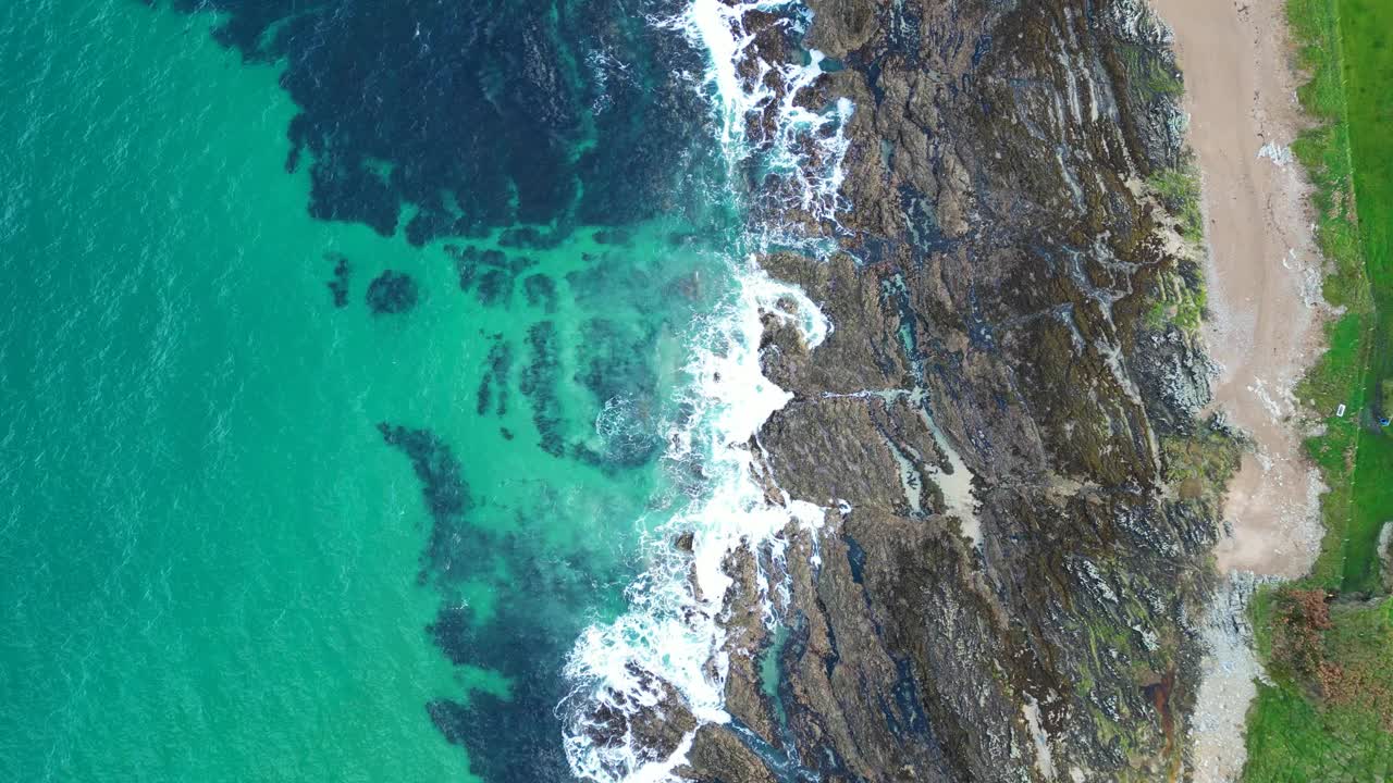 航拍海景，绿松石般的海浪冲击着海岸线上的岩石悬崖视频素材