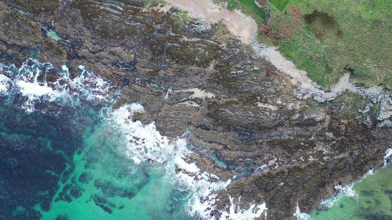 空中海景，碧绿的海浪冲击着海岸线上的岩石悬崖视频素材