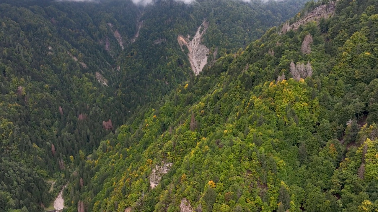 意大利，奥瓦罗米奥内——2023年4月:清晨，空中无人机拍摄了一个有云的山谷。意大利阿尔卑斯山脉绿色山坡上的小山村米奥内有漂亮的房子。视频素材