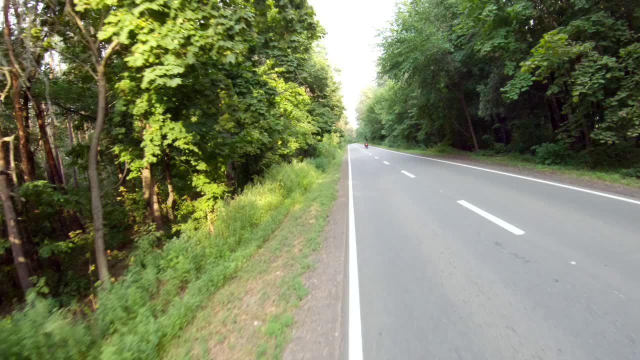 鸟瞰图骑在现代运动摩托车在空旷的农村道路。摩托车手在森林的乡村公路上驾驶摩托车。男人在旅途中骑自行车。自由和冒险的概念视频素材