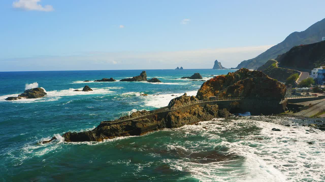 特内里费岛北部荒凉的蓝色海洋岩石海岸线。海滨小镇塔加纳。阿纳加海滩和罗克德拉斯博德加斯。海上火山岩形成的航拍画面。视频素材