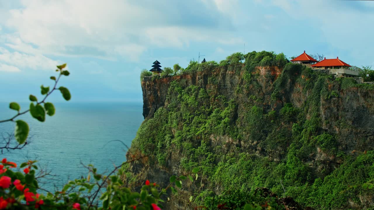 著名的热带绿色岩石海滩Uluwatu寺庙Pura Luhur印度教在巨大的悬崖深渊和无边无际的海洋地平线在巴厘岛。暑假放假。巴厘岛海水海岸线。视频素材