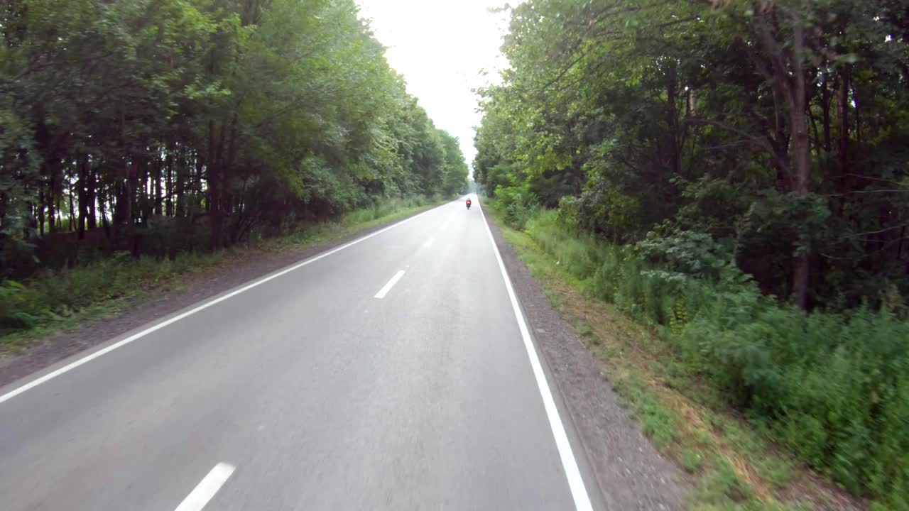 鸟瞰图骑在现代运动摩托车在空旷的农村道路。摩托车手在森林的乡村公路上驾驶摩托车。男人在旅途中骑自行车。自由和冒险的概念视频素材