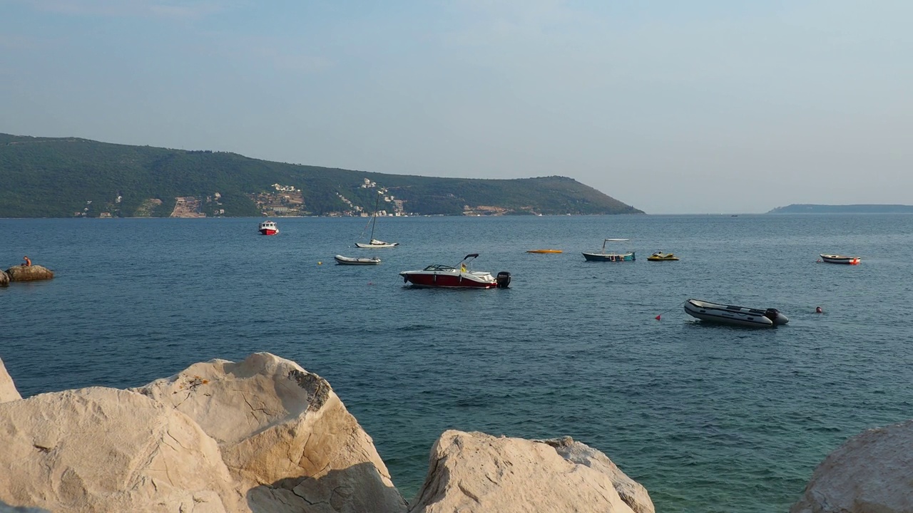 海上度假旅行。小船漂浮在亚得里亚海上。地中海旅游业务。帆船和山脉。咸水上的小涟漪。阳光明媚的天气。石头和石头。视频素材